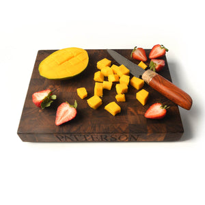 fruit being cut on personalized  walnut end grain cutting board