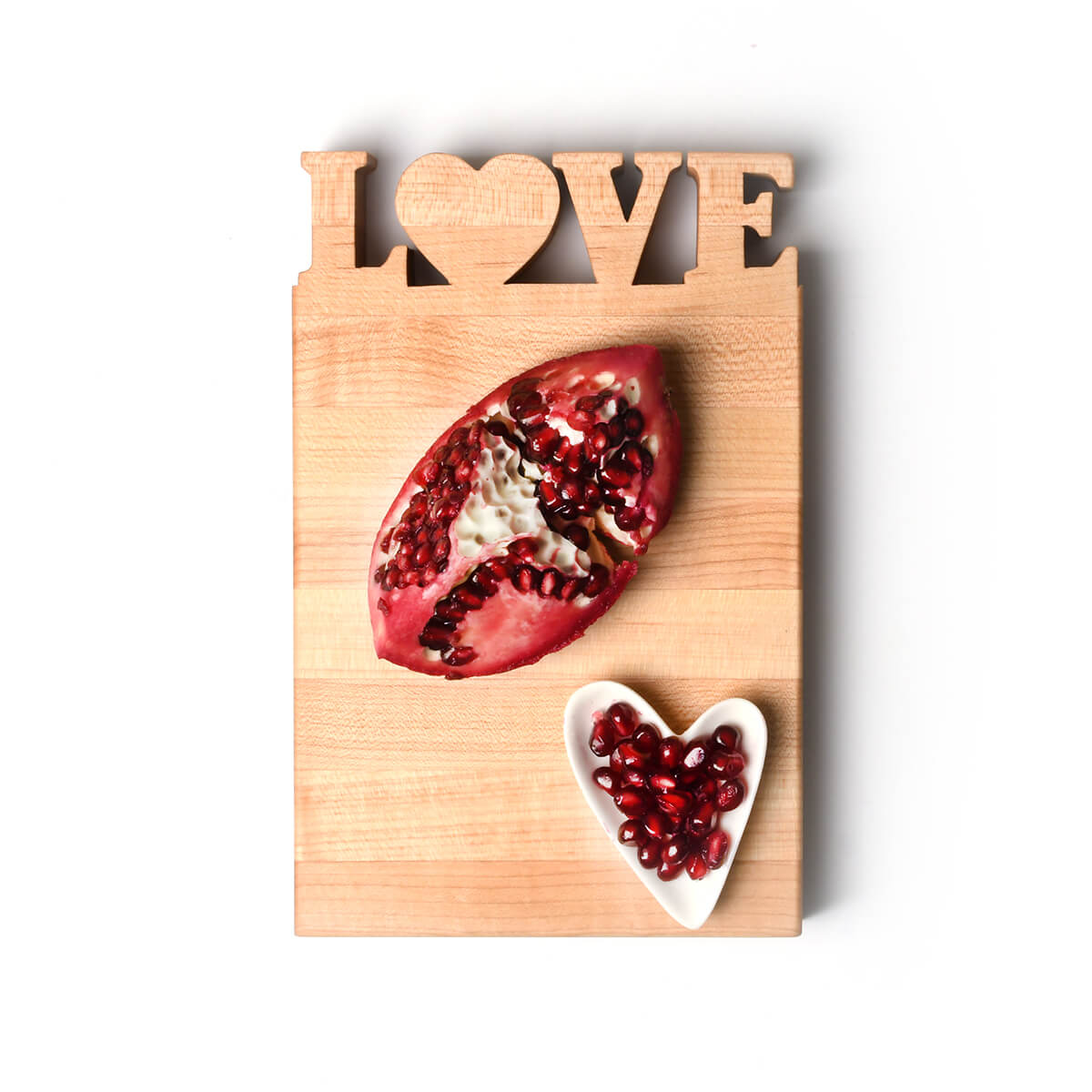 mini cutting board with LOVE cut out, shown with pomegranate