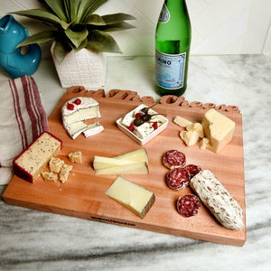 cheese board display, large wood board with the words "cut the cheese"