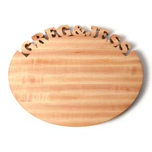 Oval personalized cutting board with Greg & Jess cut out of top 