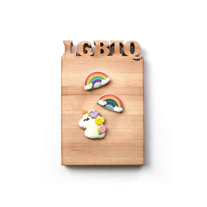 LGBTQ letters cut out of wooden cutting board