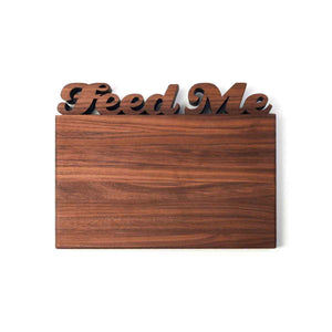 Personalized cutting board with the words "feed me" on top