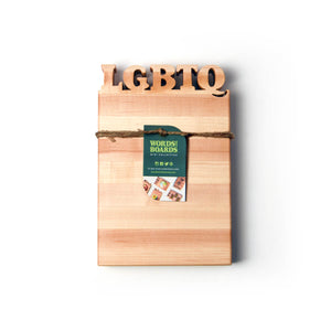 LGBTQ letters cut out of wooden cutting board