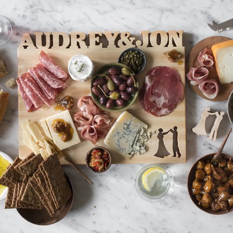 overhead: personalized wooden cutting board with charcuterie and cheese