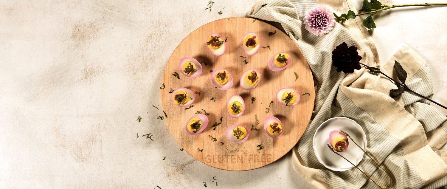Round maple board laser engraved with Seriously Gluten Free, deviled eggs on top of board on neutral background