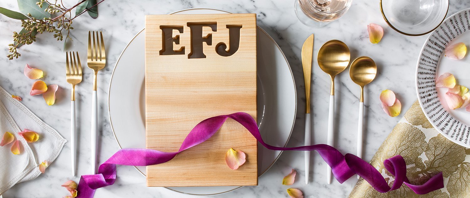 extra small maple board with 3 initial monogram cut out of wood, shown on a beautiful place setting on marble table