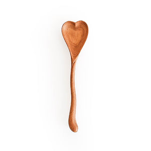 Heart-shaped wooden spoon on a white background