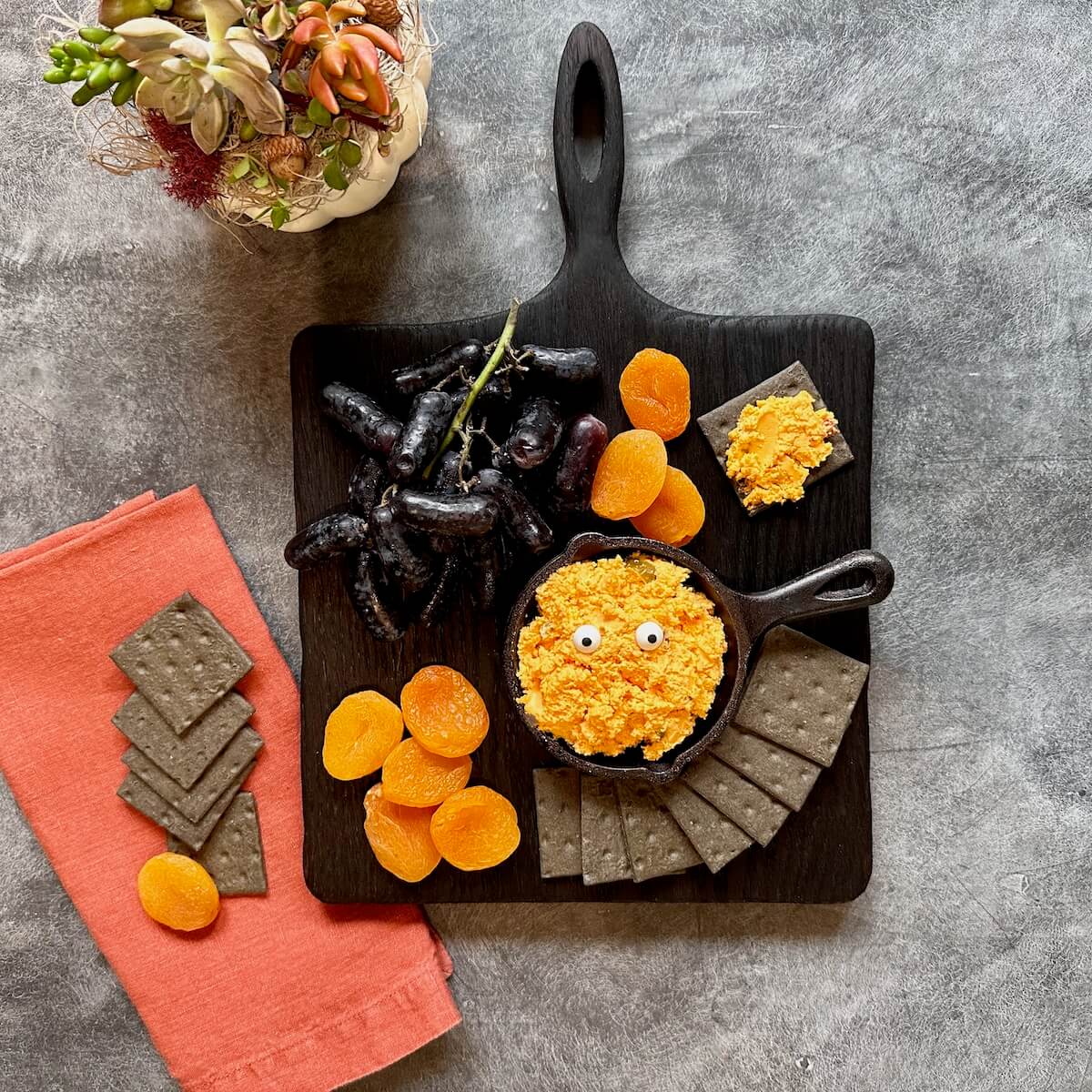 black cutting board in square shape with handle, black and orange cheese board 