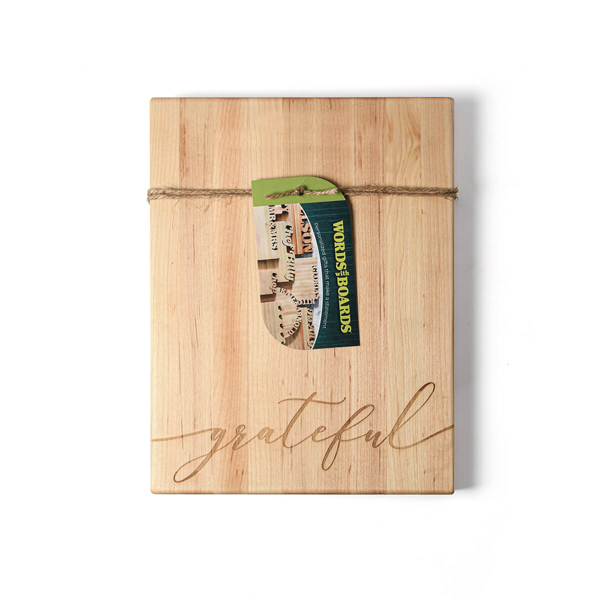 maple wood cutting board with the word  'grateful' laser engraved on the bottom. twine and tag around the board.