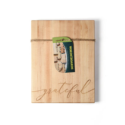 maple wood cutting board with the word  'grateful' laser engraved on the bottom. twine and tag around the board.