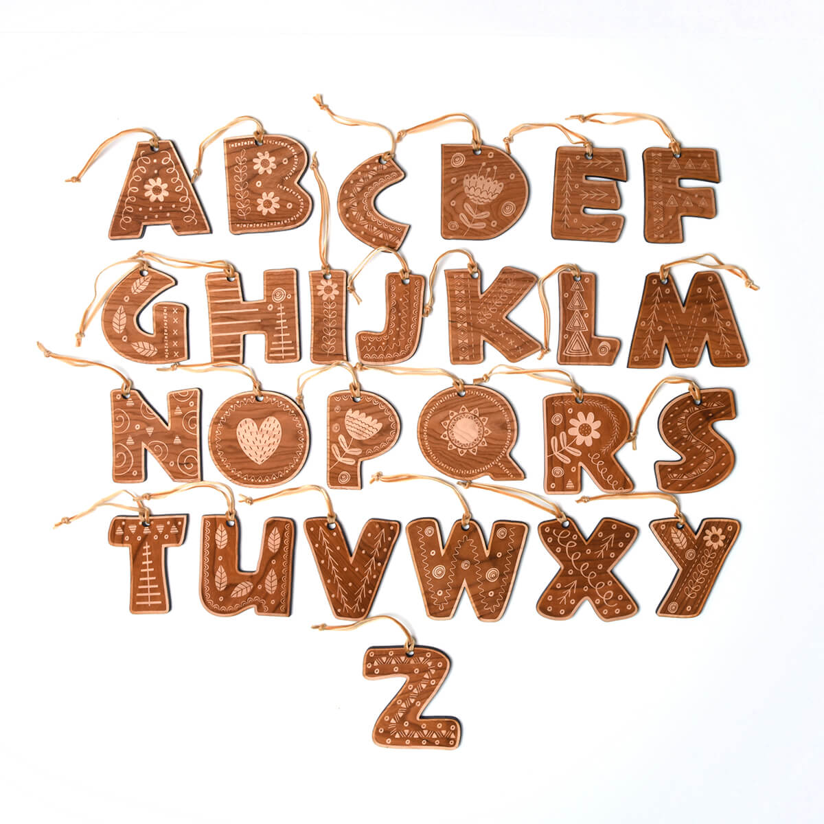 Decorative wooden alphabet letter ornaments on a white background