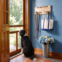 wall mount personalized Dog leash holder on hanging by door with leashes and bag hanging from it, dog looking out door