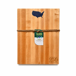 Wooden cutting board with USA shape inlaid with lapis and 'Words with Boards' tag on a white background