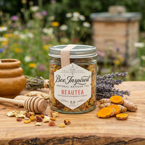 loose tea in glass jar sitting on wood with wildflowers in the background