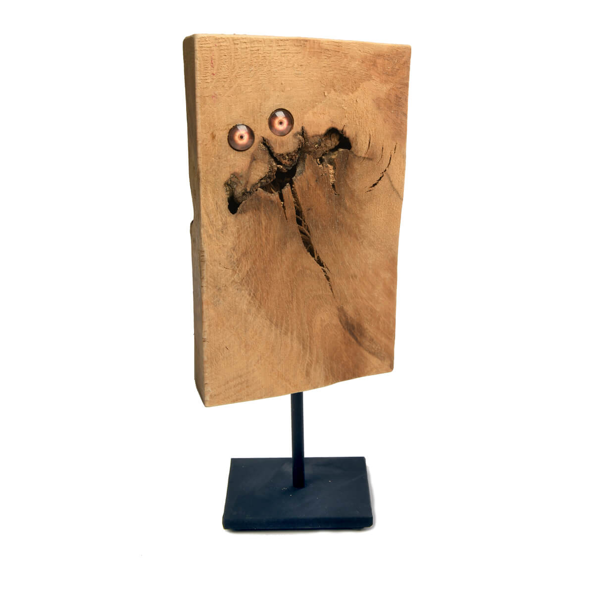 a piece of wood with a natural crack depicting a mouth with 2 glass eyes to help represent a face, shown on black stand
