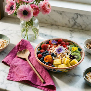 Fruit bowl, wooden heart spoon with flowers on a marble countertop