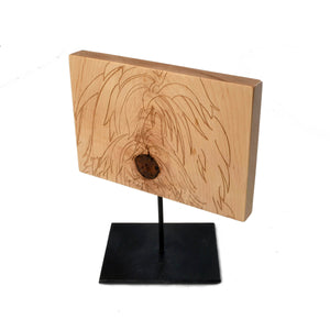 shaggy dog engraved on wood, sits on metal stand