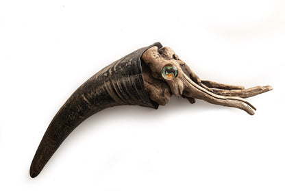 wood squid art with a large rams horn on a white background