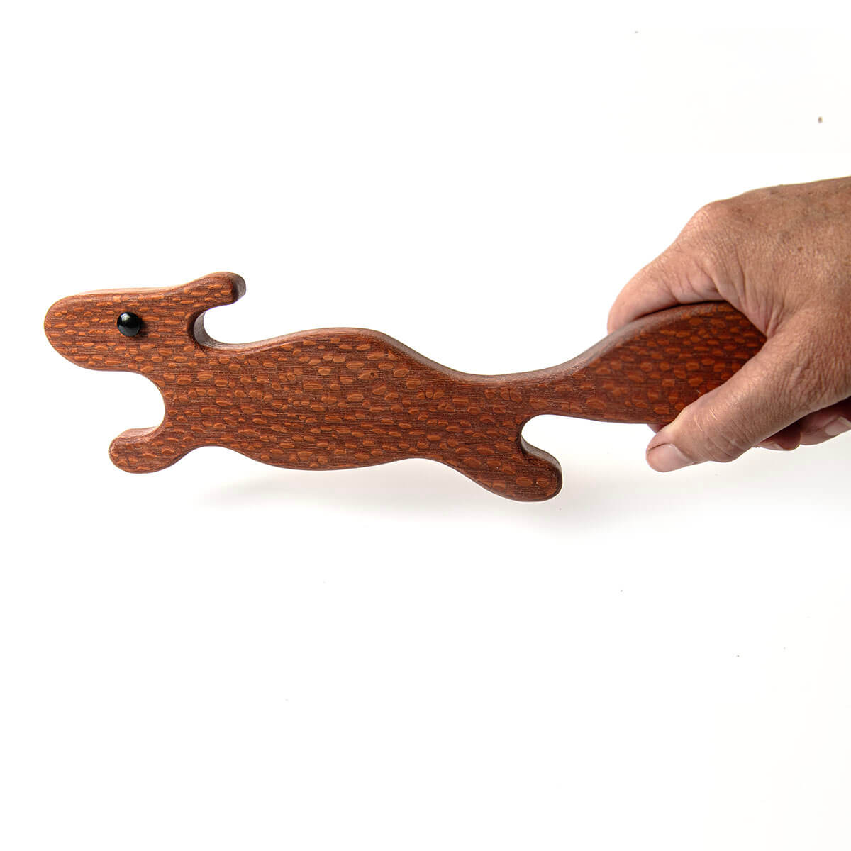 Squirell-shaped oven puller stick held by a hand on a white background
