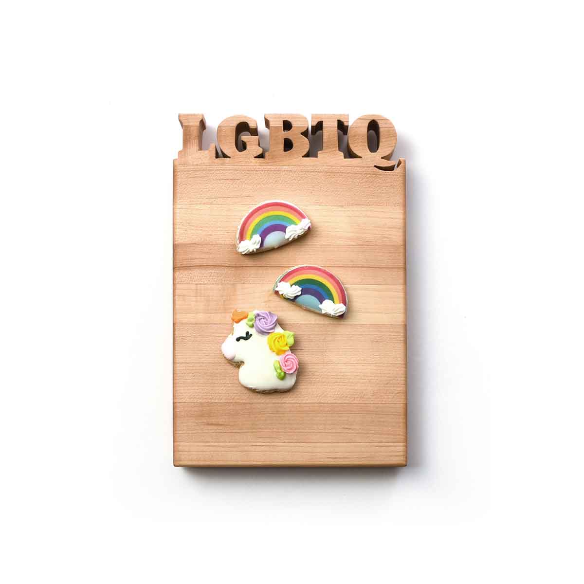 LGBTQ letters cut out of wooden cutting board