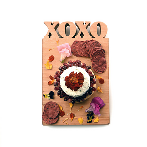 XOXO cutting board with flowers and food on it