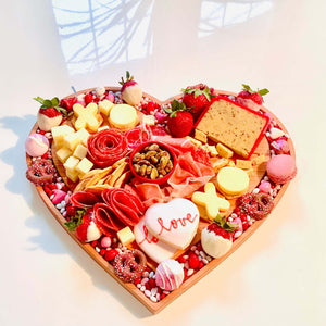 heart shaped board filled with cheese and sweets