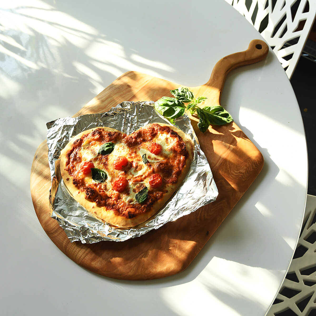 heart shaped pizza on a pizza paddle